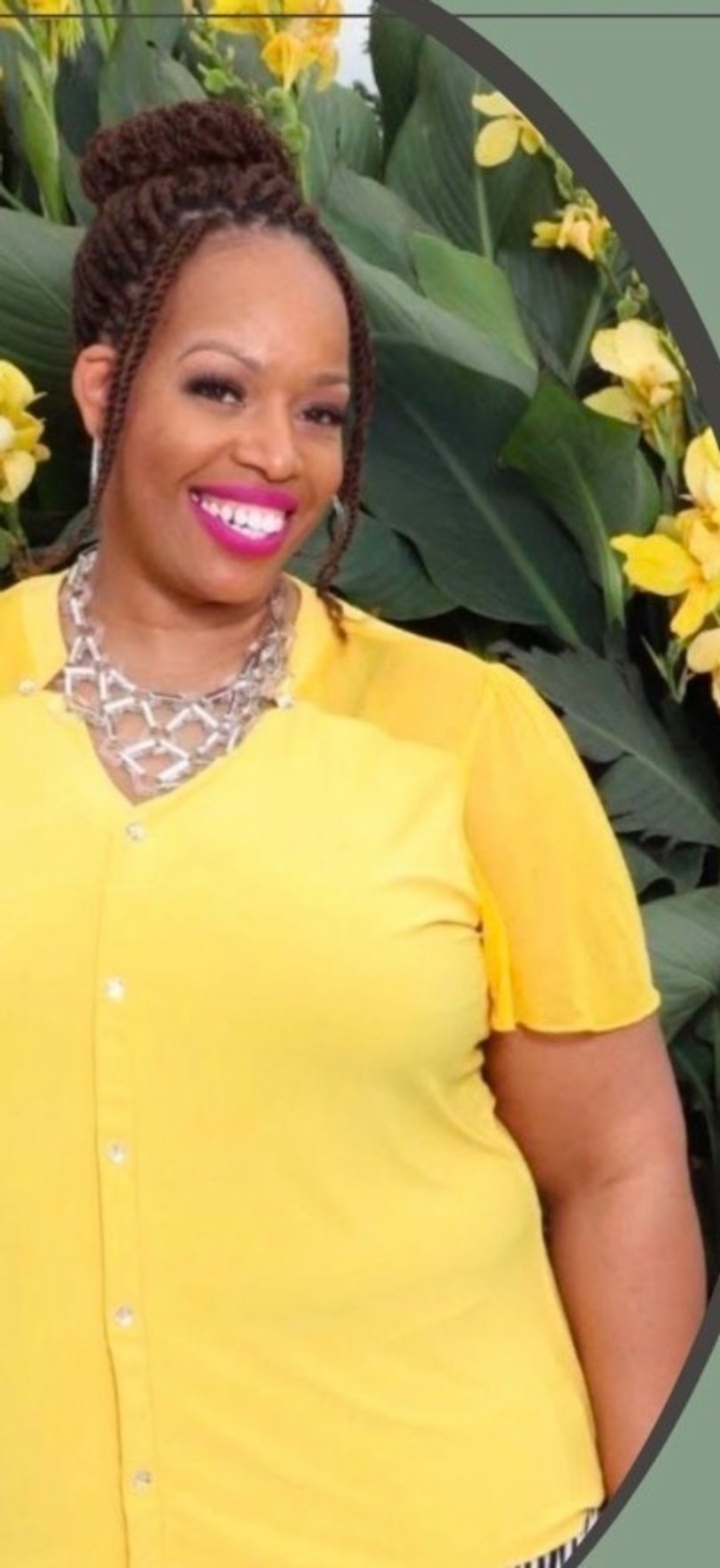 Felicia Di-Anne Robinson smiling, wearing a yellow blouse in front of yellow flowers